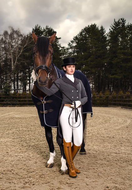 Binici açık kahverengi bir atı ile üniformalı kadın. - Fotoğraf, Görsel