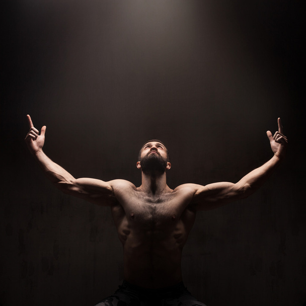 Man praying on dark studio background - Фото, зображення