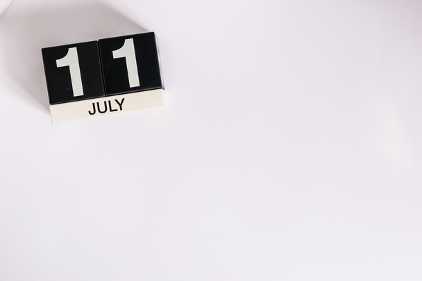 11 juli. Afbeelding van 11 juli houten kleur kalender op witte achtergrond. Zomerdag. Lege ruimte voor tekst. Wereld chocolade dag - Foto, afbeelding