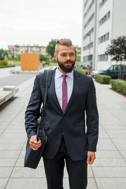 Portrait of a young happy businessman outside the office buildin - 写真・画像