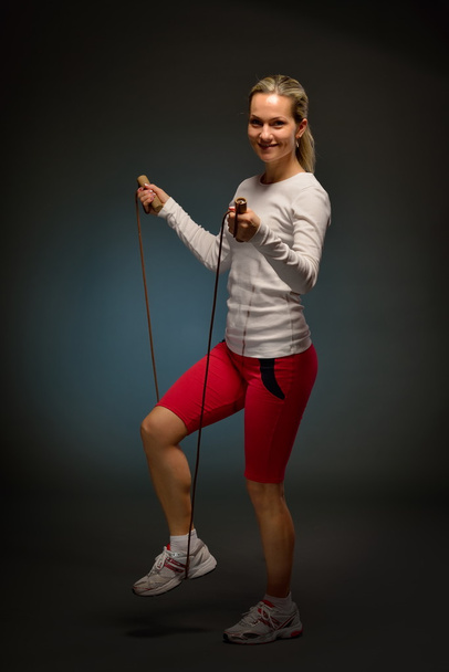 jonge atletische vrouw met springtouw - Foto, afbeelding