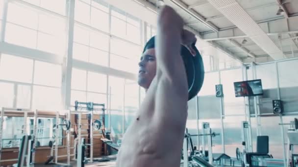 Bodybuilder hace ejercicio rotatorio con barra
 - Imágenes, Vídeo