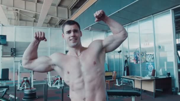 Athlete posing in gym near mirror - Footage, Video