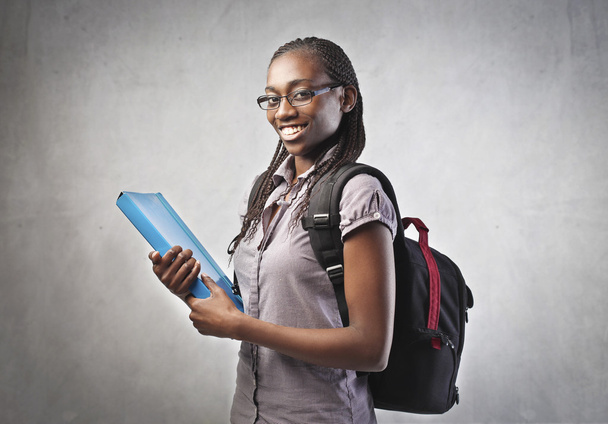 Smiling african student carrying a backpack and holding a folder - Φωτογραφία, εικόνα