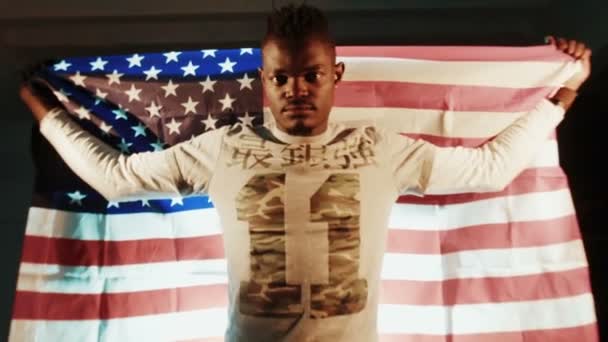 Afryki amerykański mężczyzna z amerykańską flagę w ręce - Materiał filmowy, wideo