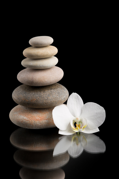 Balancieren von Zen-Steinen auf Schwarz mit weißer Blume - Foto, Bild