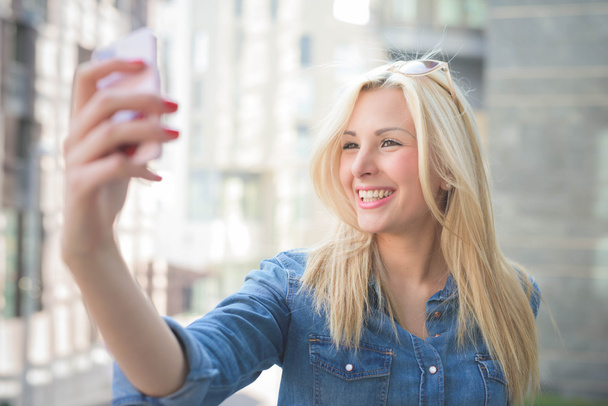 girl using a smartphone taking a selfie - Fotó, kép