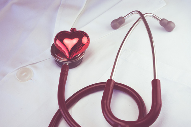 Stéthoscope et coeur rouge décoratif sur l'ensemble du médecin blanc
 - Photo, image