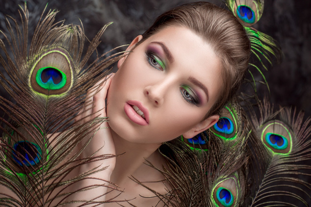 girl with bright  makeup and peacock feathe - Foto, Imagen