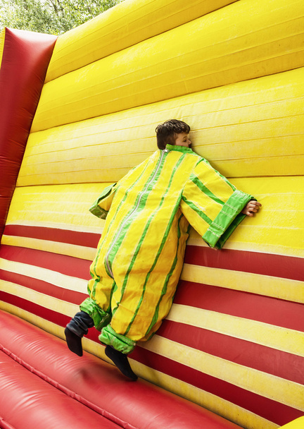 The boy in colorful plastic dress in the bouncy castle - Photo, Image