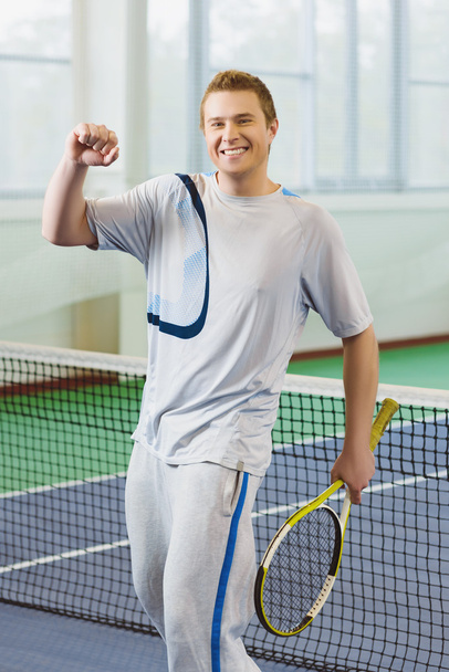 young man smiling and posing with tennis racket indoor - Φωτογραφία, εικόνα