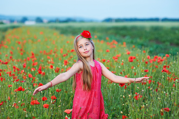gyönyörű lány piros ruhában jár: pipacs mező - Fotó, kép