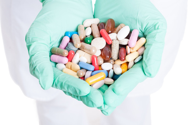 Lähikuva monia pillereitä, kapseleita ja tabletteja lääkärin käsissä
 - Valokuva, kuva