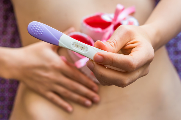 Pregnant woman holding positive pregnancy test - Photo, Image