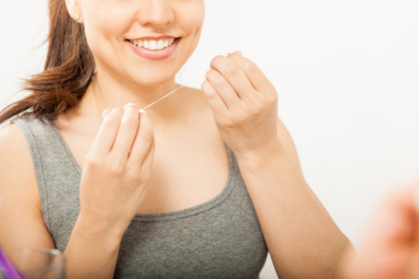 Femme utilisant de la soie dentaire  - Photo, image