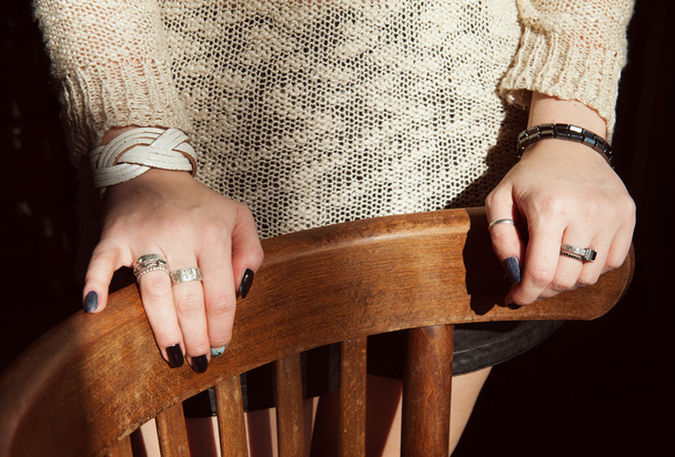 Twee handen van de jonge vrouw op stoel - Foto, afbeelding