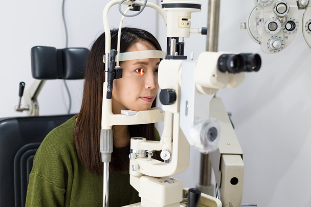 Vrouw doet oogtest in optische kliniek - Foto, afbeelding