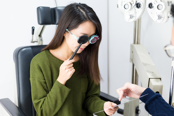 Woman doing eye test in optical clinic - Photo, Image