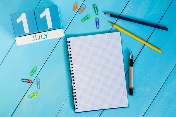Le 11 juillet. Image de juillet 11 calendrier de couleurs en bois sur fond bleu. Jour d'été. Espace vide pour le texte. Journée mondiale du chocolat
 - Photo, image