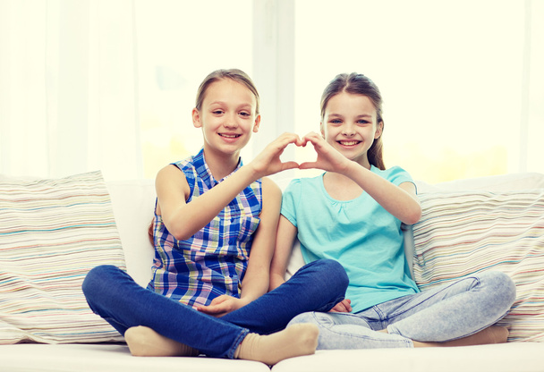 Happy μικρά κορίτσια που δείχνει το σχήμα καρδιάς χέρι σημάδι - Φωτογραφία, εικόνα