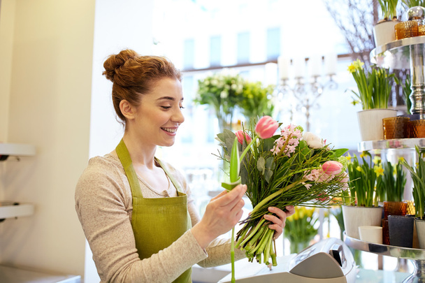 smiling florist woman making bunch at flower shop - Foto, Imagem