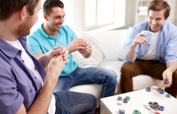 close up of male friends playing cards at home - Foto, imagen