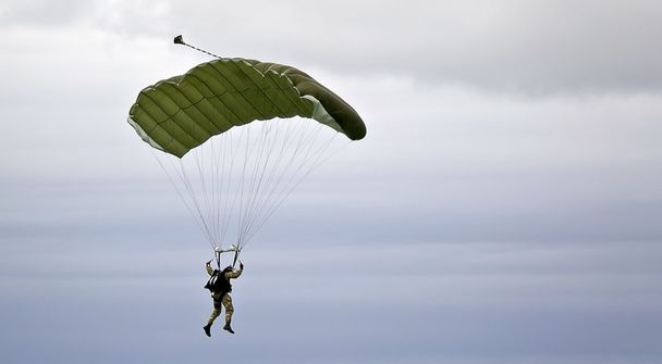 Paraquedistas militares no fundo do céu escuro
 - Foto, Imagem