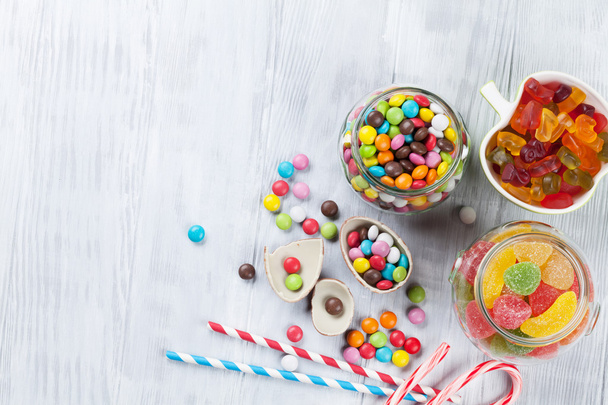 Coloridos caramelos sobre mesa de madera
 - Foto, Imagen