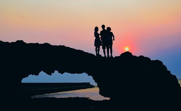gente siluetas en roca de playa
 - Foto, imagen