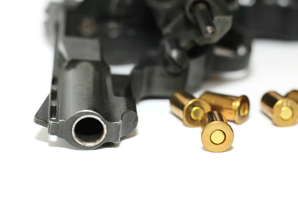 Foto einer schwarzen Revolverpistole mit Patronen auf weißem Hintergrund - Foto, Bild