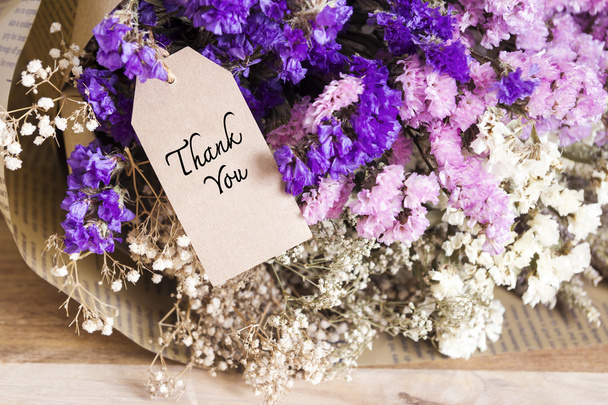 Strauß getrockneter Blumen mit Dankeskarte auf dem Holztisch - Foto, Bild