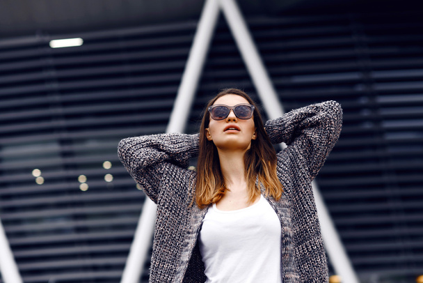 Beautiful girl in a cardigan, shirt and sunglasses outdoor - 写真・画像