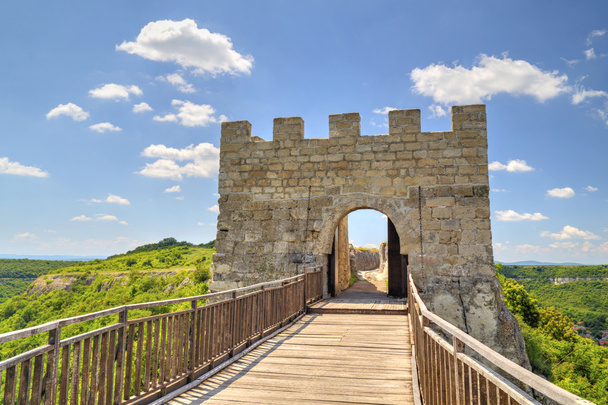 Kőfalak és kapu a középkori erődítmény fahíd - Fotó, kép