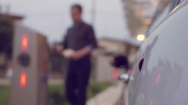 Homem carregando seu carro elétrico
 - Filmagem, Vídeo