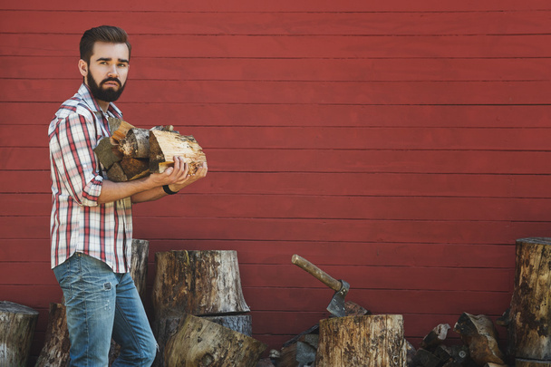 Bearded man is holding firewoods - Foto, Imagem