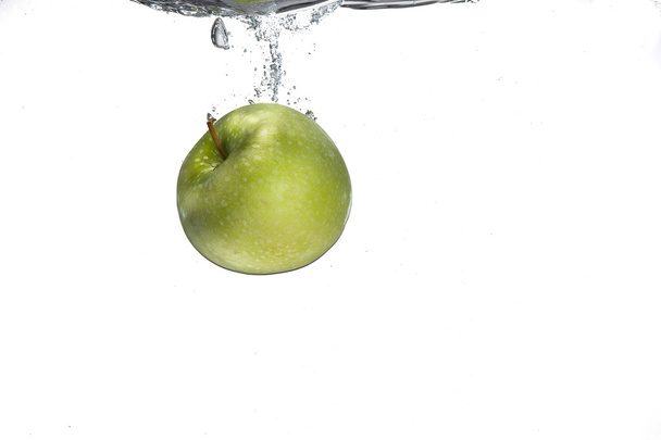 grüner Apfel fiel in etwas Wasser. - Foto, Bild