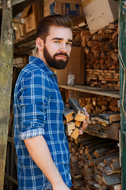 Bearded man with firewoods - Foto, afbeelding