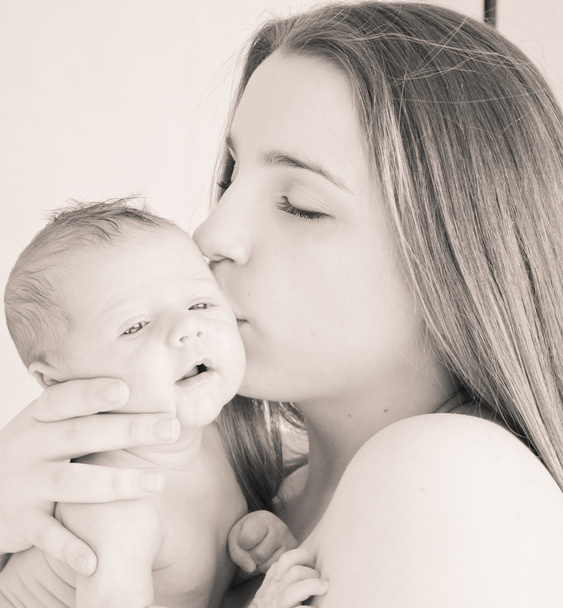 Foto van gelukkige jonge moeder met pasgeboren baby - Foto, afbeelding