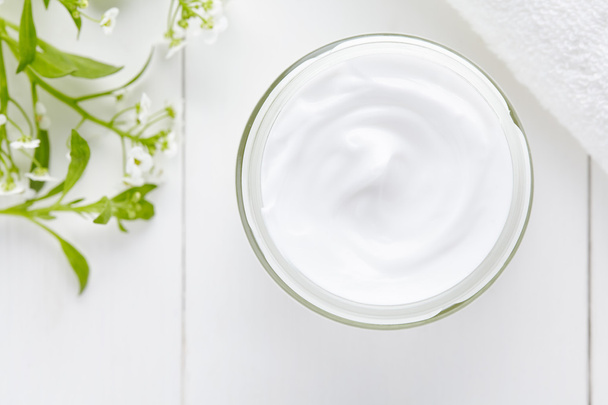 Cosmetische crème met kruiden bloemen op witte achtergrond - Foto, afbeelding