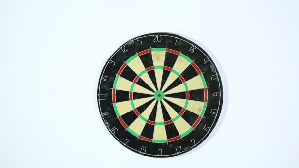Een dart lijkt de bulls-eye van een dartbord. Brede shot van een dartboard van onderaf, Darten drie met een schot in de roos.  - Video