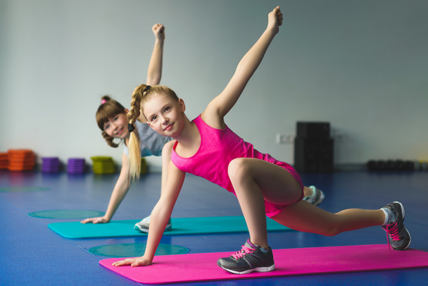 Lányok csinálás gimnasztikai gyakorlatokat vagy fitness osztály gyakorlása - Fotó, kép