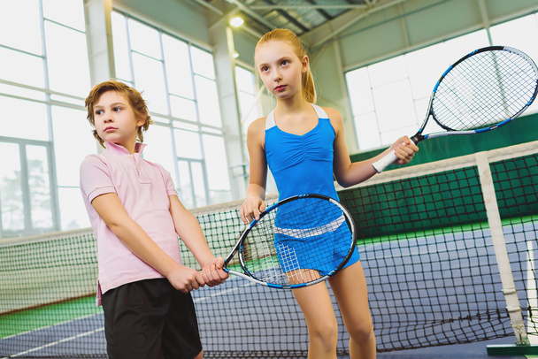 Children playing tennis and posing indoor - Foto, afbeelding