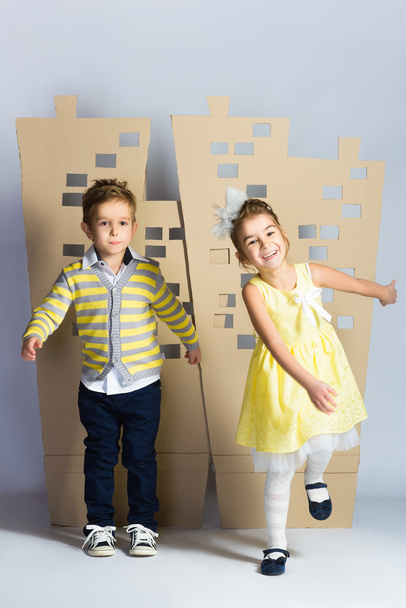 Love concept. Couple of kids. boy and girl with  cardboard town - Фото, зображення
