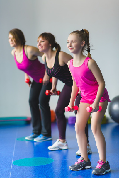 Dos mujeres jóvenes y una niña haciendo ejercicios de gimnasia
 - Foto, Imagen