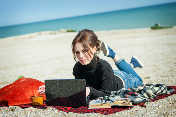 young woman enjoying her working on the beach - Фото, изображение