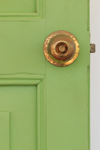 Deur knoppen gemaakt van messing met groene oude houten deur. - Foto, afbeelding