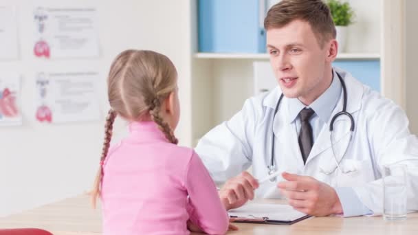 Positive doctor examining a little girl - Imágenes, Vídeo