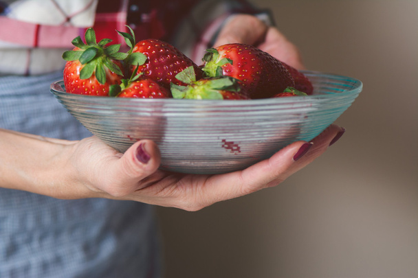Woman  with bowl of strawberries in hand. - Zdjęcie, obraz