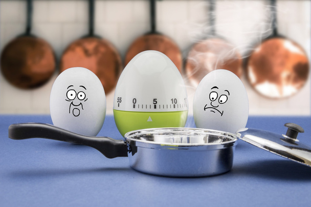 due uova con faccia spaventata guardano una padella per friggere in una cucina
 - Foto, immagini