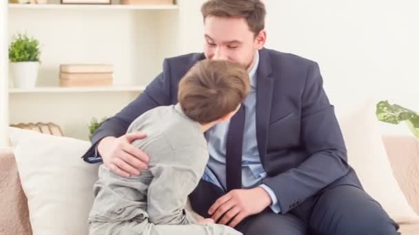 Positive father and son sitting on the couch - Filmati, video